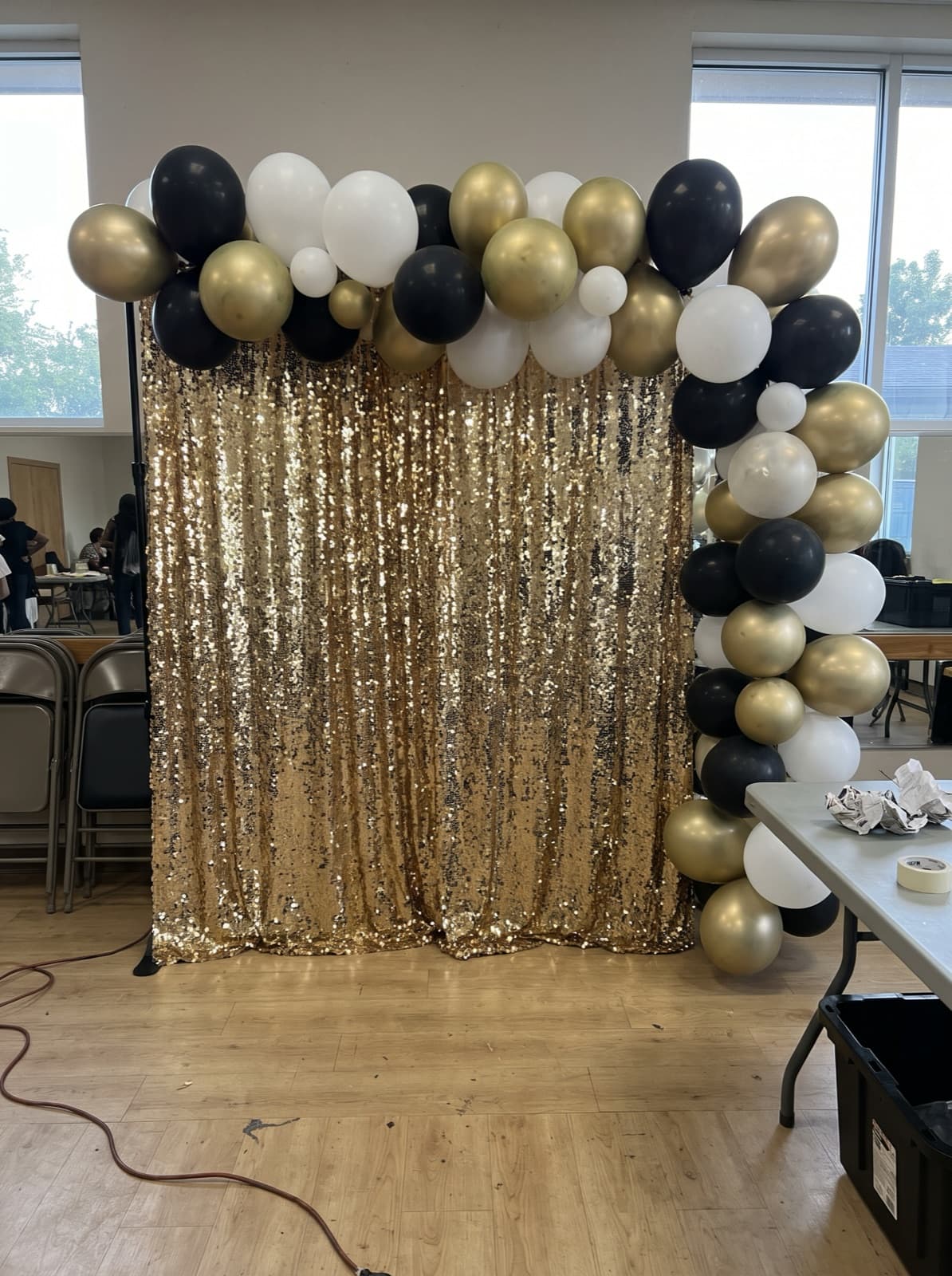 Shimmer wall in gold sequins topped with a balloon garland