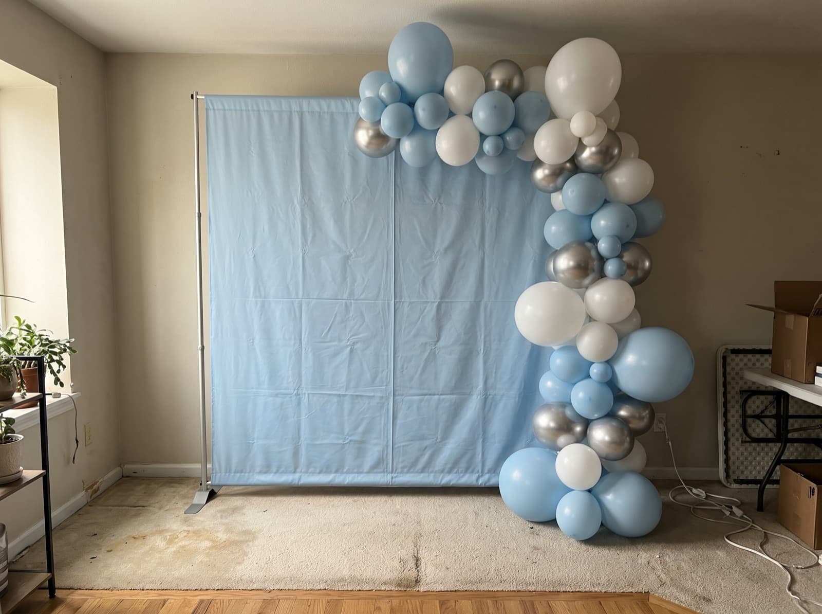 Square backdrop with a blue and silver garland up one side
