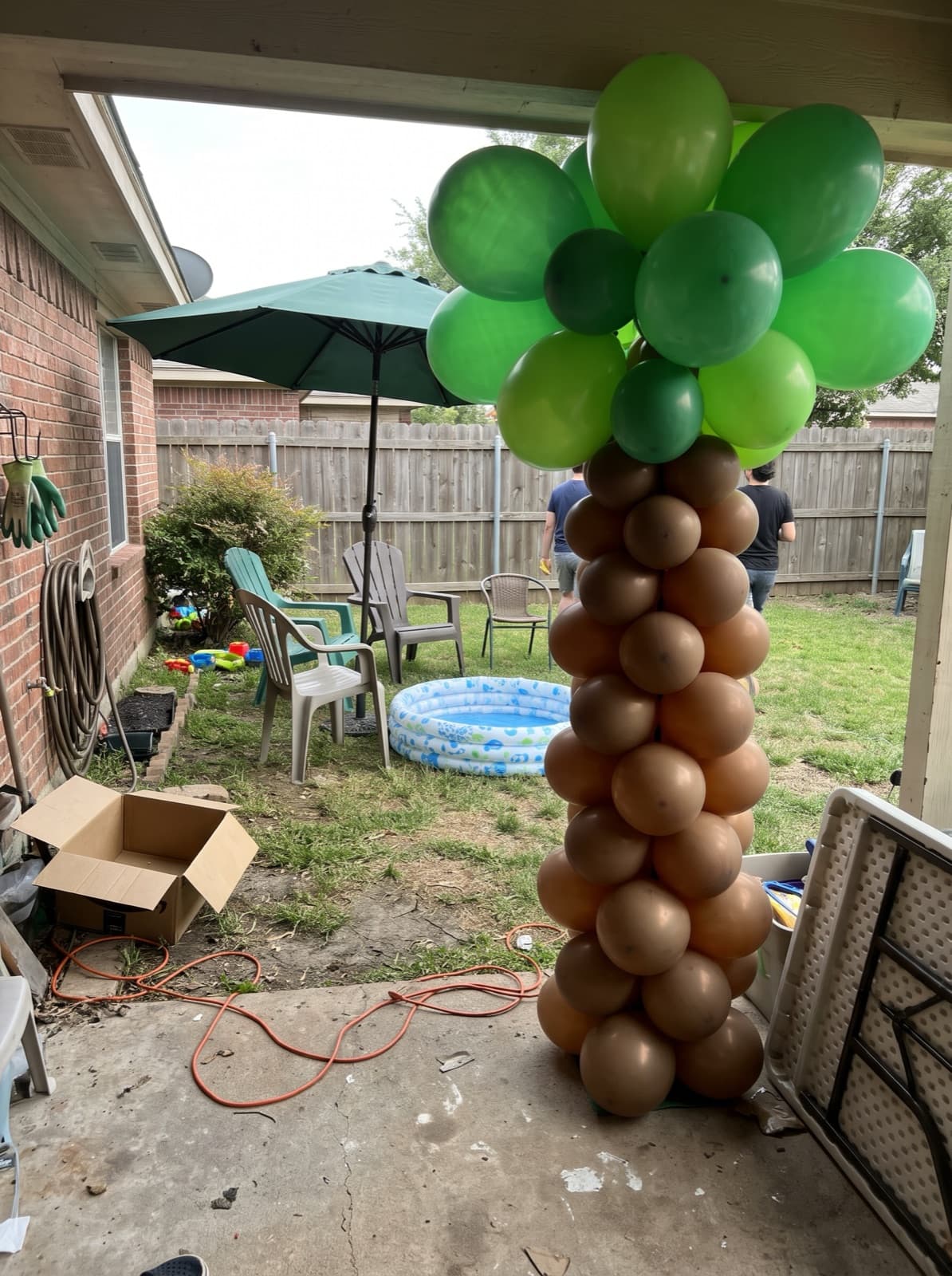 Palm tree balloon column at a backyard summer party