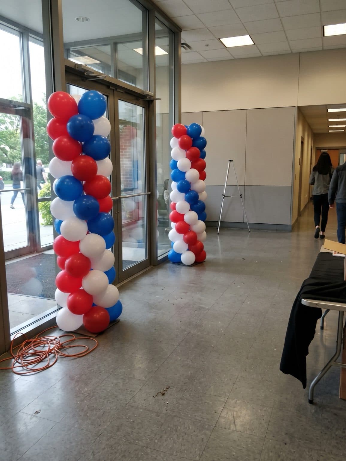 Red, white and blue spiral balloon columns at an office entrance