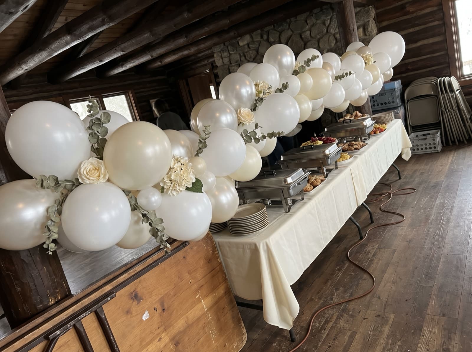 Pearl balloon garland with eucalyptus along a buffet in a lodge-style room
