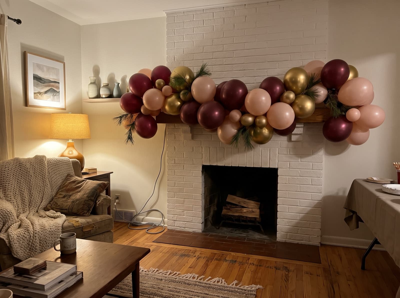 Burgundy, blush and gold balloon garland on a white brick mantel