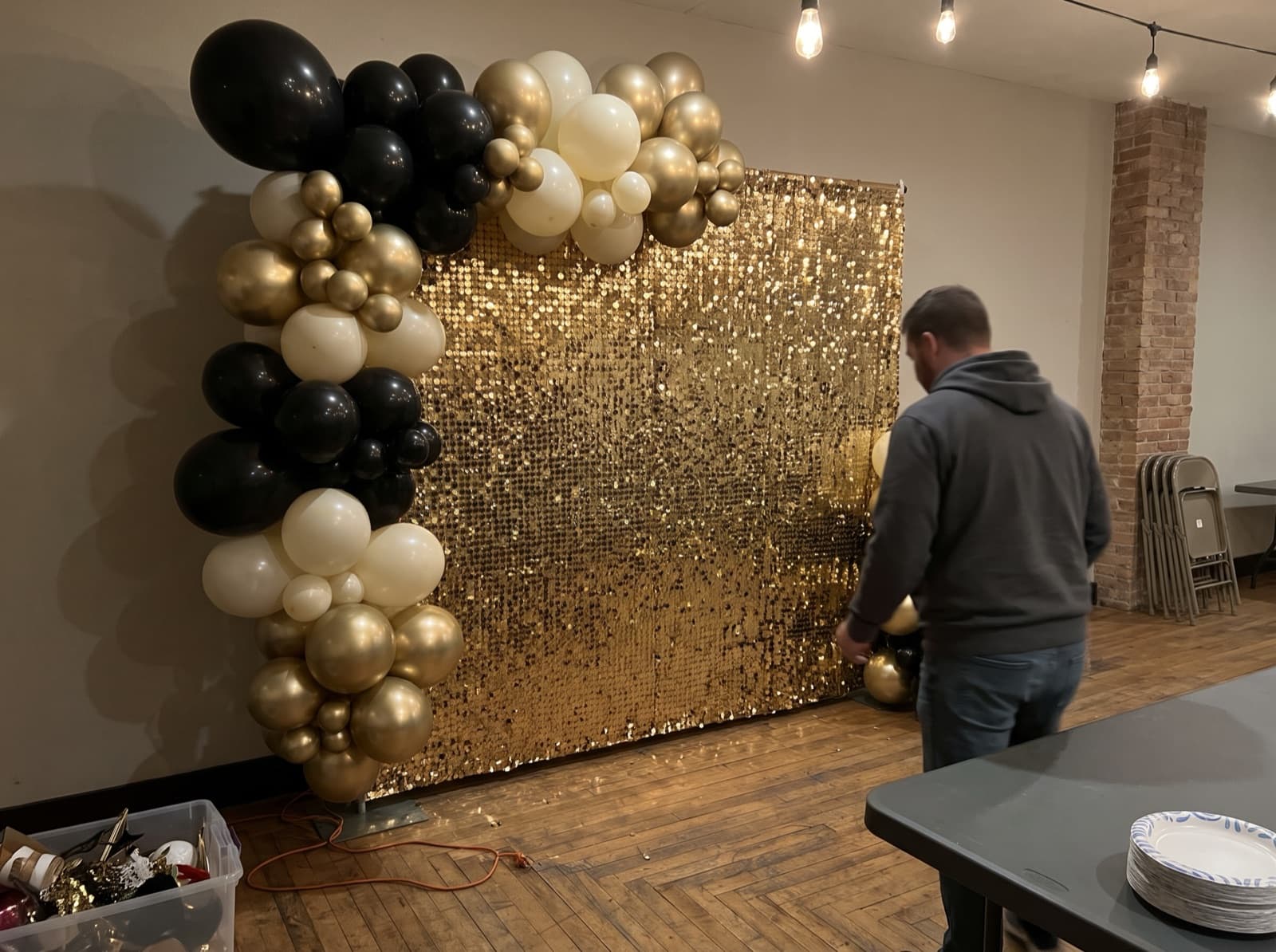 Black, white and gold balloon garland over a gold shimmer wall