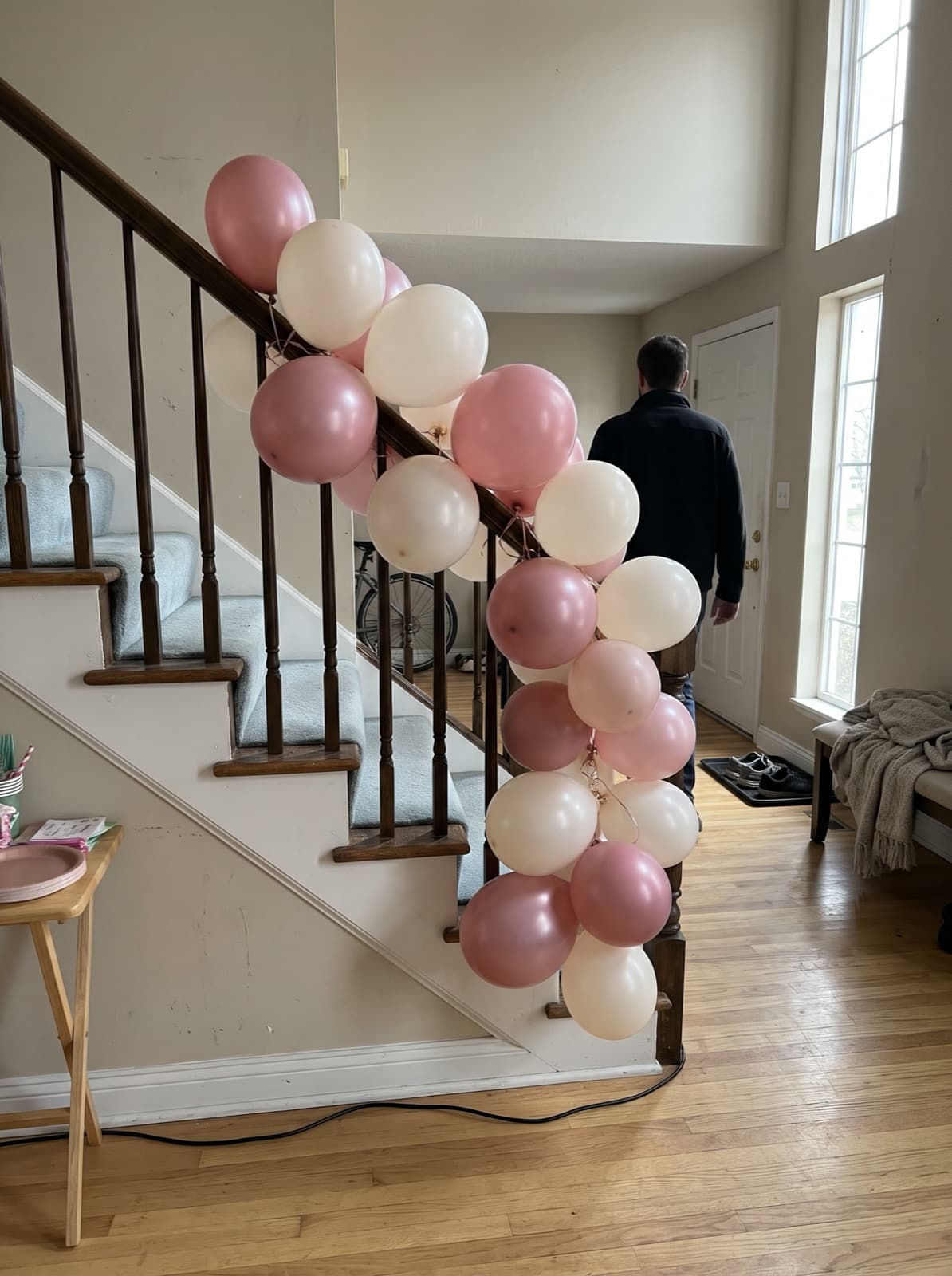 Balloon garland in blush and white down a staircase banister