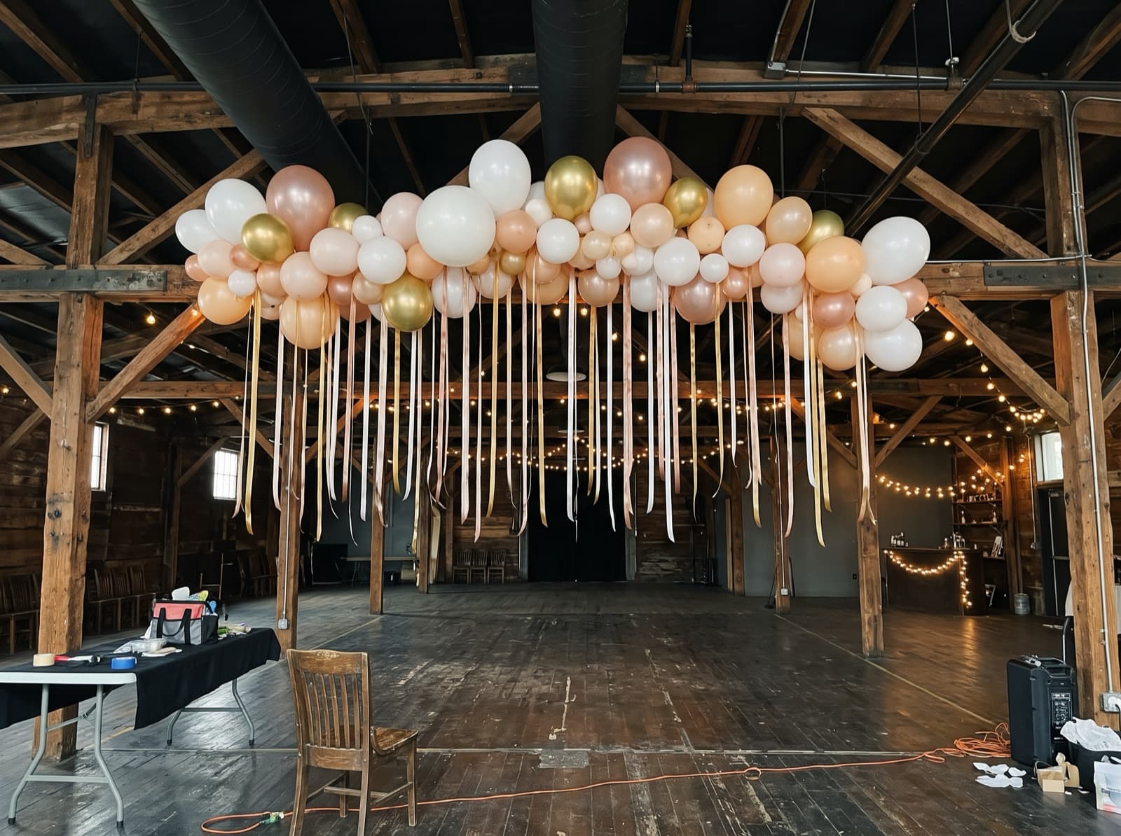 Balloon ceiling of white, blush and gold balloons over a dance floor in a Denver event venue