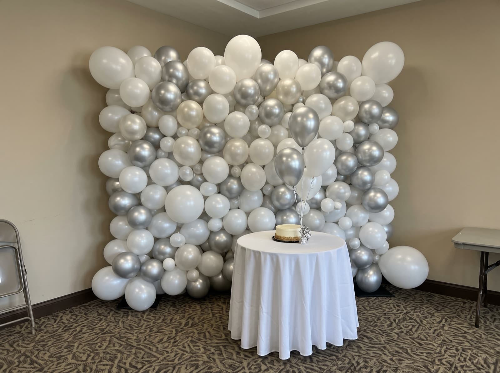 Organic balloon wall in white, pearl and silver in a hotel ballroom